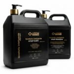 Dois frascos plásticos pretos com bombas douradas com o rótulo Kit Lavatório Inteligente Coiffeur (Smart Balm 5 em 1 + Smart Shampoo), cada um com 2,5 L, para lavatório inteligente, mostram informações detalhadas sobre o produto em espanhol.