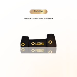 A Toalha Lizzon, preta, registrada e dobrada com o logotipo amarelo Lizzon Professional e detalhes geométricos, está centralizada sobre fundo branco. Acima dela aparecem as palavras "toalha" e "FUNCIONALIDADE COM ELEGÂNCIA".